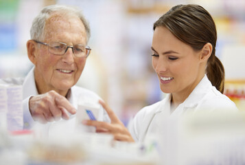 Ensuring customers find what they need. Shot of a young pharmacist helping an elderly customer. - Powered by Adobe