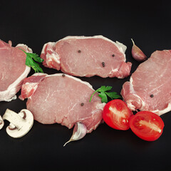 Raw meat beef steak on dark background in row with spices on dark background.