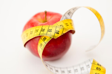 Diet Concept with apple and measuring tape. Weight loss, counting calories and healthy eating concept - calculate daily nutrition intake. Isolated on white background.