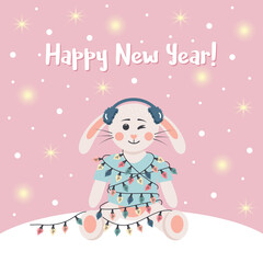 Сute rabbit in winter headphones is wrapped in a garland. Winter card with shining lights and snow. Happy New Year text.