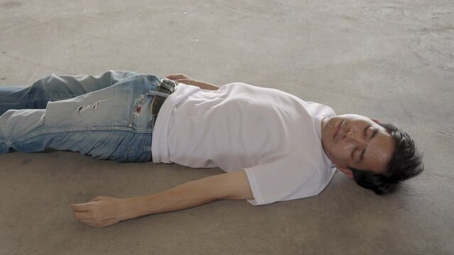 Man lying unconscious on cement floor due to extreme heat, heat stroke, global warming, CO2 emissions.