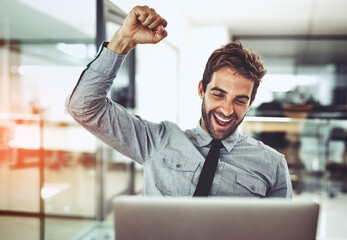 Its a victory worth celebrating. Shot of a handsome young businessman doing a fist pump while...