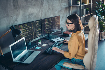 Profile side view portrait of attractive focused skilled girl web developer using laptop at...