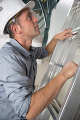 a worker in uniform going up the ladder
