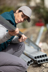 female builder holding a length of metal