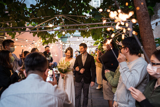 Loving newlyweds with guests on wedding day