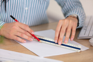 cropped image of hands drawing line with scale ruler
