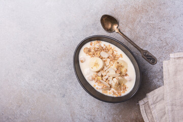 Healthy breakfast of granola with fresh banana, nuts and yogurt