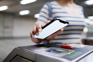 Cropped shot of young Asian woman scanning QR code, checking in at subway station, making a quick...