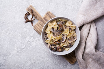 Bowl of italian farfalle pasta and mushrooms with cream sauce