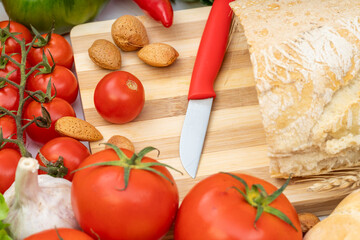 A kitchen knife with a red handle on a wooden cutting board