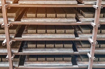 Front view of paving slabs drying on factory shelves. Production background.