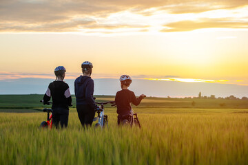 family on cycle ride in countryside. Healthy lifestyle - family biking. happy family -mother with...
