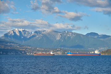 Freighters Anchored English Bay Vancouver. Anchored freighters in front of the Coast Mountains in English Bay.

