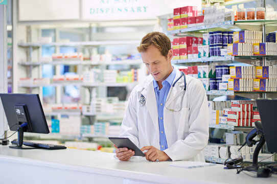 Now I Can Keep Track Of Everything. A Pharmacist Working On A Digital Tablet.