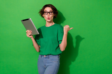 Photo of charming impressed woman dressed summer t-shirt eyewear typing gadget empty space isolated green color background