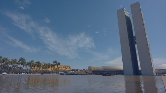 panning shot over the water at the National Congress including the Chamber of Deputies and the Senate strategically located in the capital Bras&iacute;lia