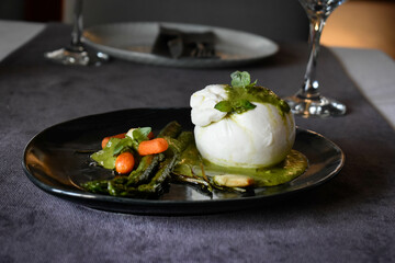 Burrata on pesto sauce with asparagus and carrots