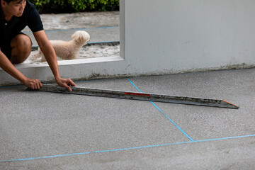man working on explsed aggregate finish the front of the house