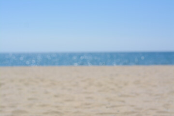 Fototapeta na wymiar Sandy beach near sea on sunny day, blurred view