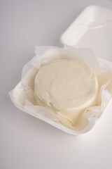 Small white cake without decorations in the package. Delivery of desserts