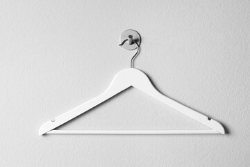 Empty wooden clothes hanger on white wall