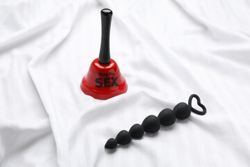 Anal beads and bell with text Ring For Sex on white fabric - obrazy, fototapety, plakaty