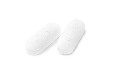 Two calcium supplement pills on white background