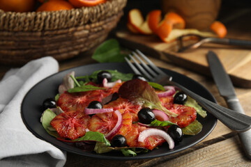Plate of delicious sicilian orange salad on wooden table, closeup