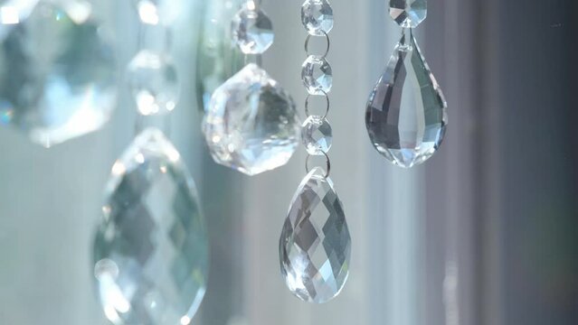 Selective focus hanging crystals close up, sun catcher, gently moving light prisms.