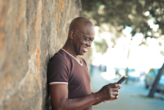 mature man uses a smartphone in the street