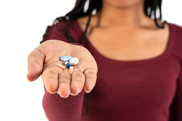 Young black woman showing some pills in her hand