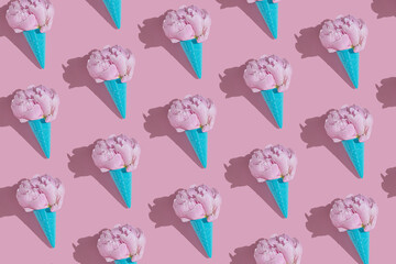 Creative blue toy ice cream cone with pink peony fluffy flower on pink minimal background with copy space flat lay. Botany idea for summer or spring wallpaper or greeting card. Seamless pattern.