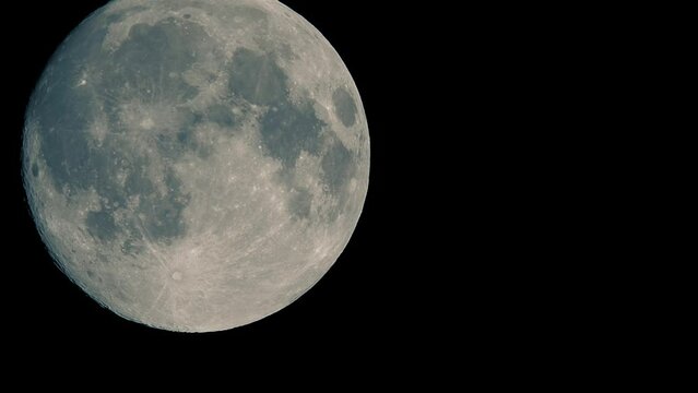 Full moon moves fast at night sky. Sharp footage of full moon with telephoto lens close-up. Moon shot from ground. Moon witchcraft magic ritual concept.