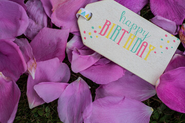 Happy Birthday Schild auf Rosenblätter