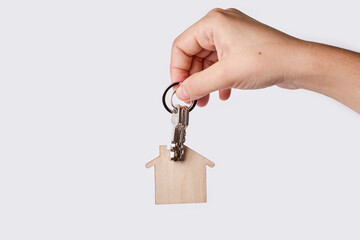 Hand is holding wooden house modelon white background. Concept for new home, property and estate.
