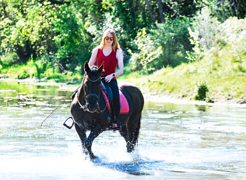 riding girl and horse in river