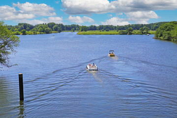 Beautiful idyllic dutch lakescape, 2 motor sport boats, green forest, ,blue summer sky - Leukermeer, Netherlands