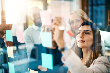 Planning is always a crucial step in success. Shot of a group of businesswomen arranging sticky...
