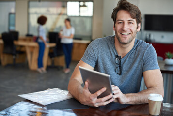Designed with mobility in mind. Portrait of a young man using a digital tablet in an office.