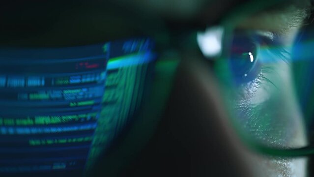 Closeup portrait of software engineer working on computer. Line of hack code run in reflection. Developer or hacker working on innovative application using computer. Big data or programming concept