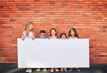 Well keep an eye on this space for you. Portrait of a group of young children holding a blank sign...