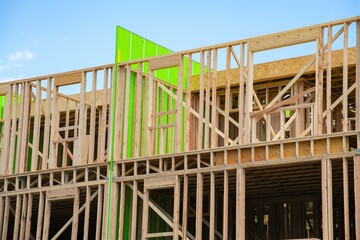 New apartment building under construction on sunny day plywood frame facade