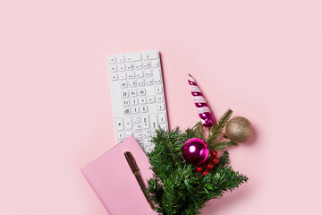 Pink notebook and christmas tree on pink backgraund. Flat lay desk with pink notebook and christmas decoration. Working, business, office, home work, winter holidays, greeting card concept