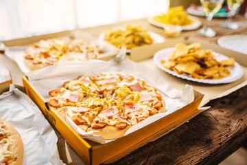 Desk of pizza party, crispy, french fry and white wine glasses wear on old weathered wooden desk in business office.