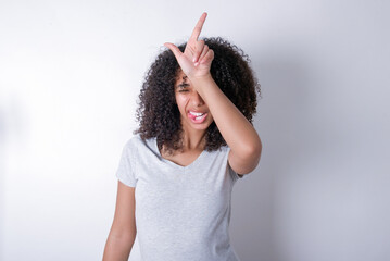 Young beautiful girl with afro hairstyle wearing gray t-shirt over white background gestures with...