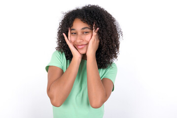 Fototapeta na wymiar Young beautiful girl with afro hairstyle wearing green t-shirt over white background Pleasant looking cheerful, Happy reaction