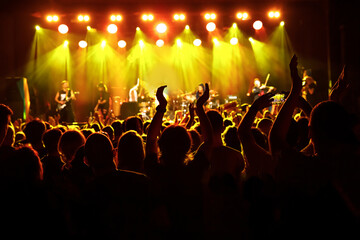 Silhouette of people with raised hands on music concert - obrazy, fototapety, plakaty