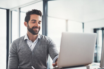 Working hard to maintain his lead in the business game. Shot of a young businessman working on a laptop in an office.