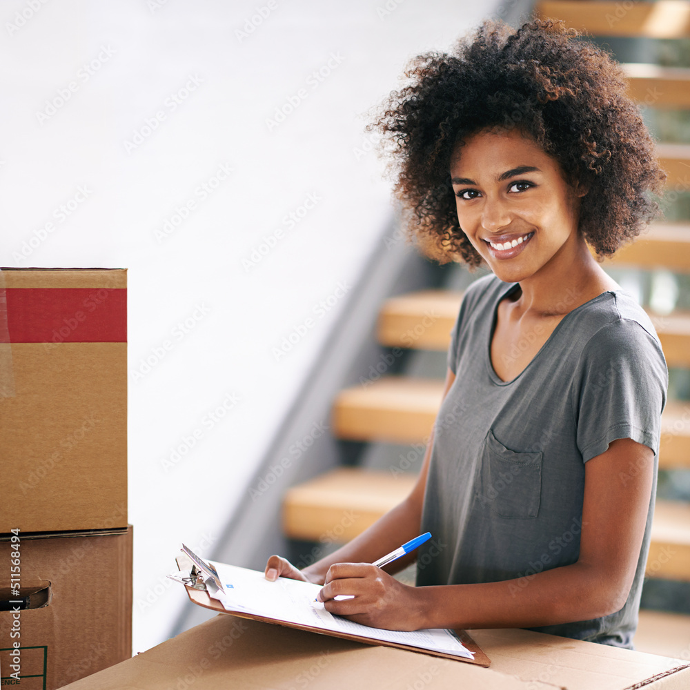 Canvas Prints Looks like my to do list is fully checked. Shot of a young woman checking her clipboard while busy packing up.